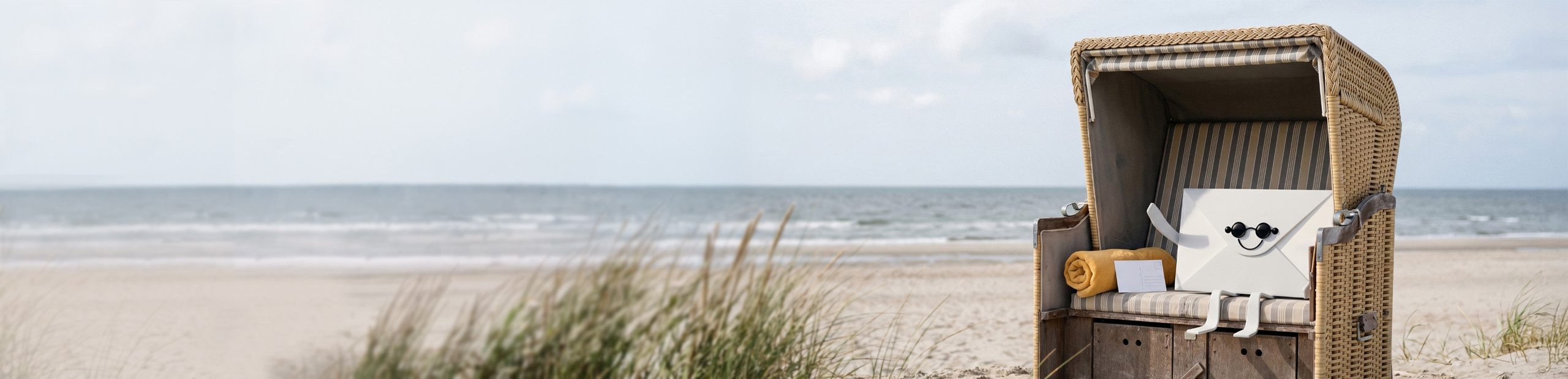 Bild mit Strankorb am Meer, in dem ein Brief mit Augen und Mund, genannt Letti, sitzt