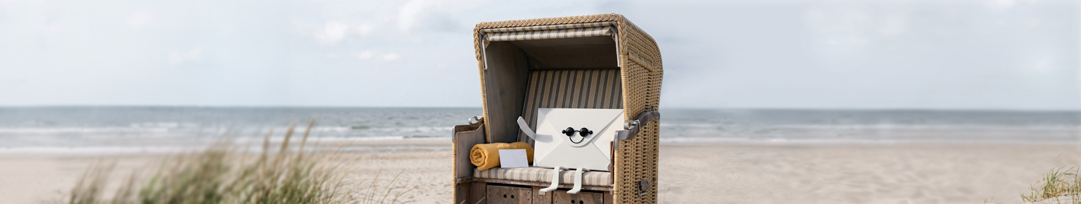 Bild mit Strankorb am Meer, in dem ein Brief mit Augen und Mund, genannt Letti, sitzt